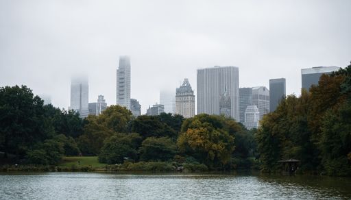 A New York skyscrapers on a rainy day seen from Central Park lake