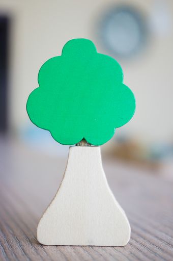 A closeup vertical shot of a miniature wooden tree on a table