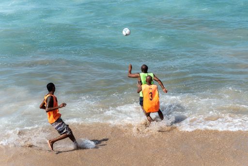 A shot of people playing sand football at Farol da Barra beachfront in Salvador city, Bahia, Brazil
