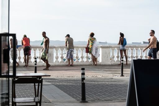 A shot of people walking through the streets of Porto da Barra under the summer Sun