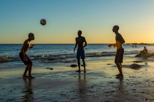 A beautiful view of young people playing sand football at sunset on the beach in Salvador, Brazil