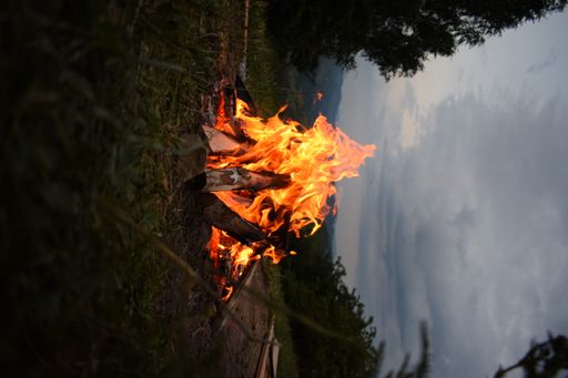 A vertical shot of a bonfire burning on the field.