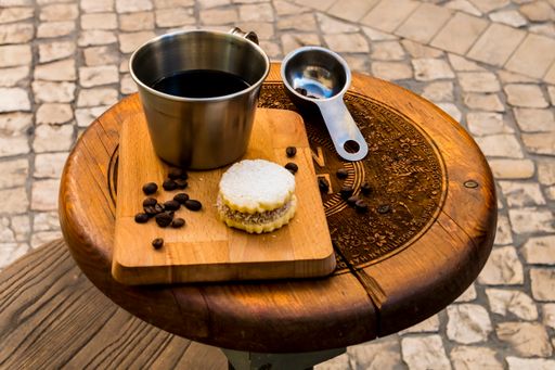 A closeup of a coffee mug with a delicious cookie on a board