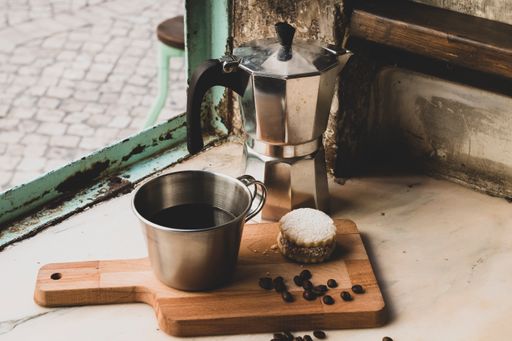 A closeup of a coffee mug with a delicious cookie on a board