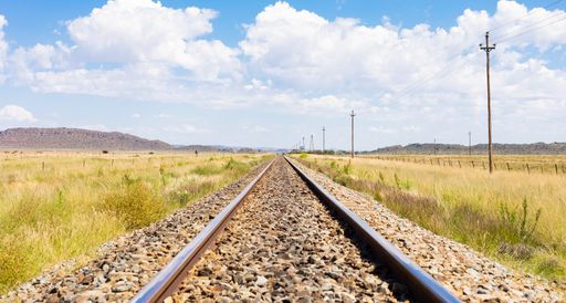 An empty steel railway track in countryside rural farmland area of South Africa