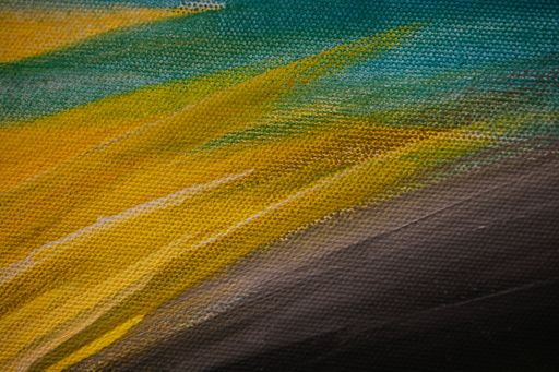A closeup of an abstract multicolour painting on canvas under the lights
