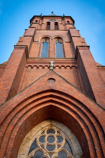 A low angle shot of Papenburg church tower against blue sky on a sunny day