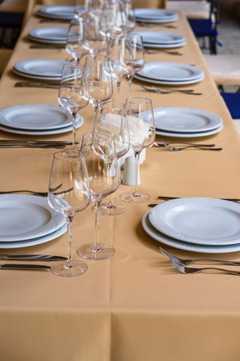A festive table setting with empty wine glasses and white plates during an event