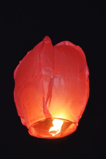 a vertical shot of a flying red paper sky lanterns