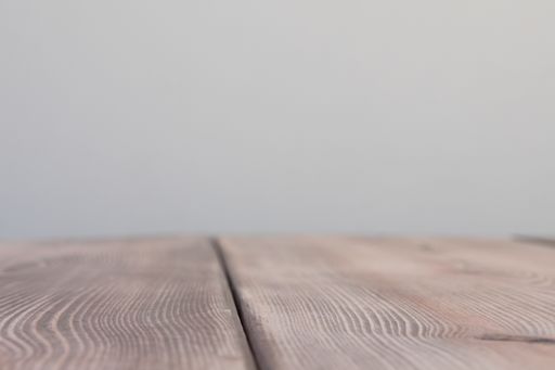 A closeup shot of a wooden table under the lights on a blurry background