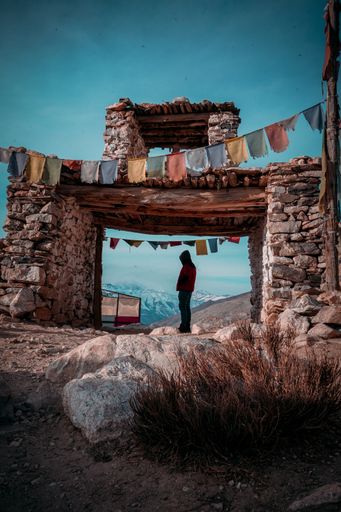 A vertical shot of a man in the Nako village, Spiti Valley at the entrance of a holy gate