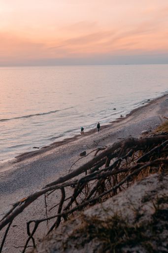 A vertical shot of the sea surrounded by the beach under the sunlight during the sunset