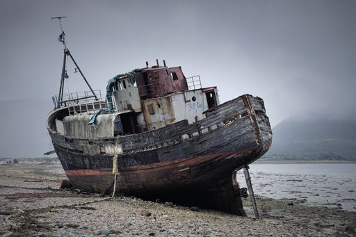 The place of a shipwreck, the abandoned former fishing trawler boat on the shore. Scotland.