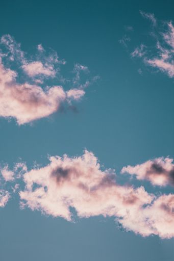 A vertical low angle shot of the magnificent fluffy clouds in the blue sky