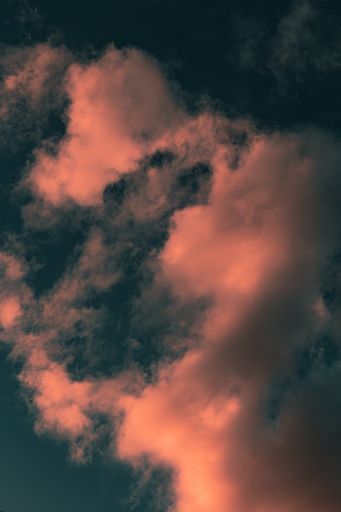 A vertical low angle shot of the magnificent fluffy clouds in the blue sky
