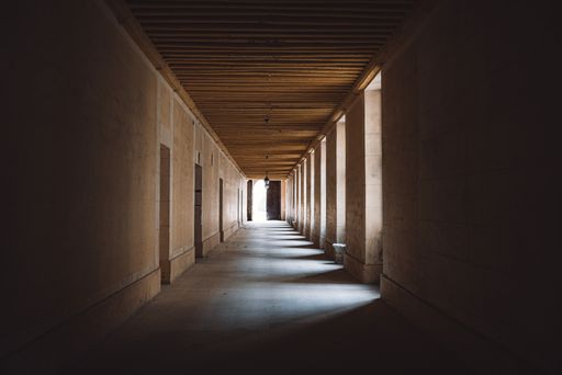 A closeup of a long hallway with lights between columns