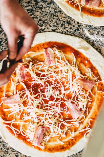A closeup of a man preparing a pizza