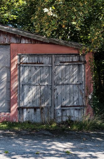 A vertical shot of a barn with large wooden doors
