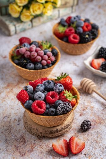 A vertical shot of various fresh berries on a table