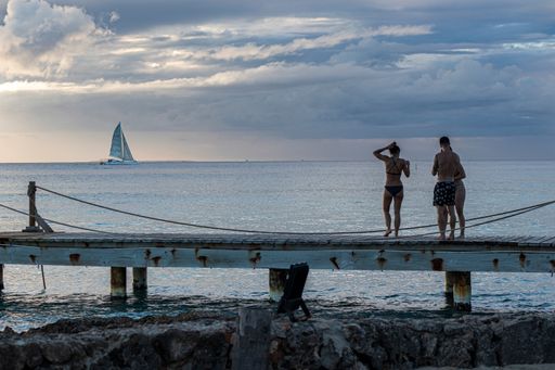 Dominican sunset on Pier with people watching the sea