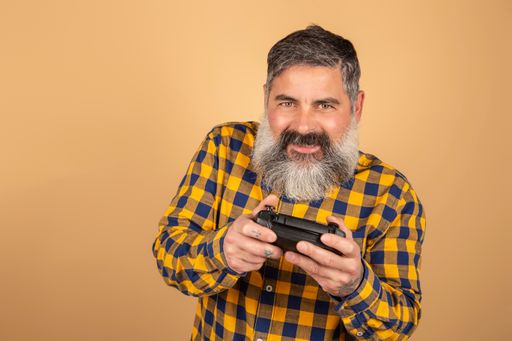 Handsome Caucasian gamer with a beard playing a video game using a joystick with an excited face.