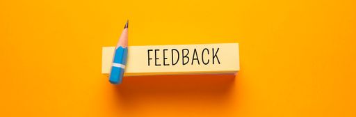 Feedback written on a sticky paper pile isolated on a yellow background