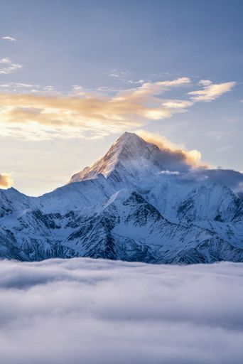 A vertical shot of the Gonggar Mountain covered in the snow during a beautiful sunrise in China