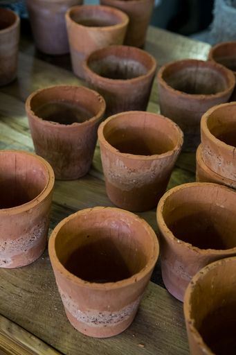 A vertical shot of a several pots made of clay on a wooden surface