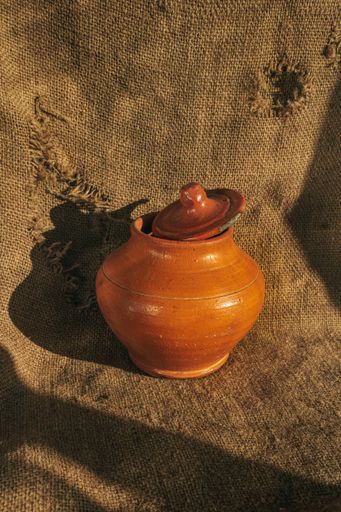 A closeup shot of  clay pot on a burlap background