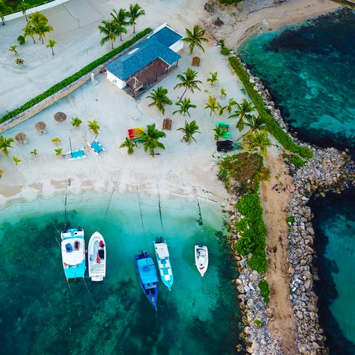 An aerial shot of Cabarete Beach with boats parked near the shore and some palm trees