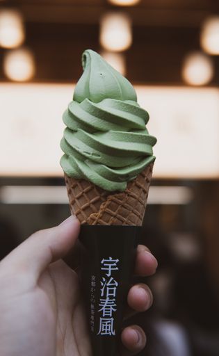 A vertical shot of matcha Ice Cream in a hand in China, Suzh.