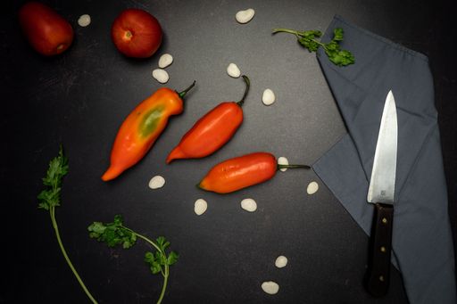 A top view of red chili peppers on a black messy kitchen table