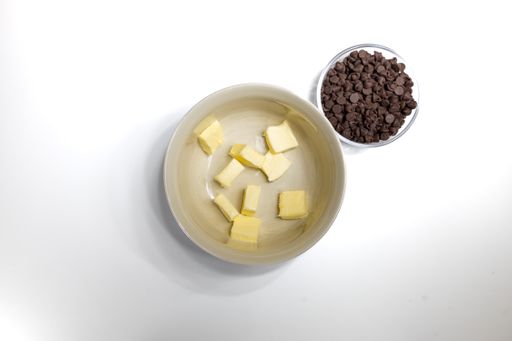 A top shot of a bowl of cube butter and chocolate chips isolated in a white background