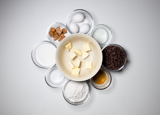 A top shot of a bowl of butter in the center and other backing ingredients isolated in a white background