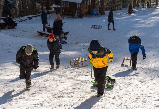 Winter scene with people enjoying in winter activities on sledding hill at Sljeme near Zagreb, Croatia. Families and children having fun on snow