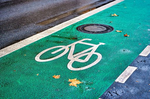 White bike symbol on the green painted tarmac of a cycleway in Berlin.