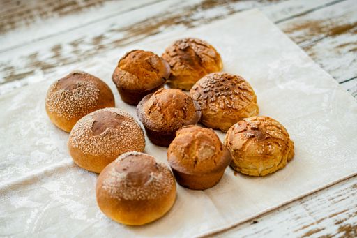 A closeup shot of freshly baked buns, cupcakes, and cookies on a wooden surface