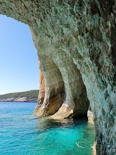 A vertical shot of the caves and rocks in the sea on a sunny day in Zakynthos, Greece
