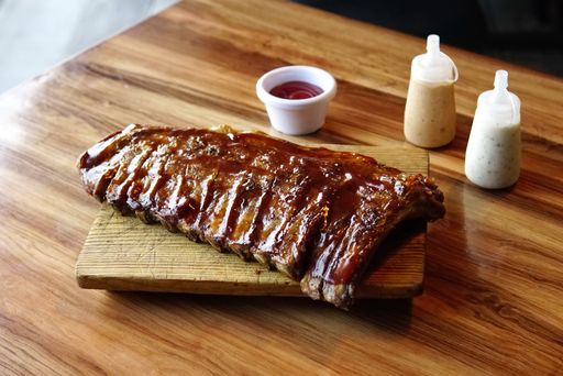 A closeup shot of pork ribs made with honey sauce on a chopping board