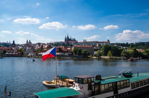 A view of Moldova River in Prague, and the cityscape with flying Czech flag