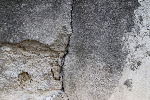 A closeup shot of a concrete wall texture with cracks - perfect for background