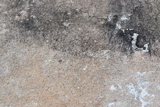 A closeup shot of a weathered concrete wall with cracks