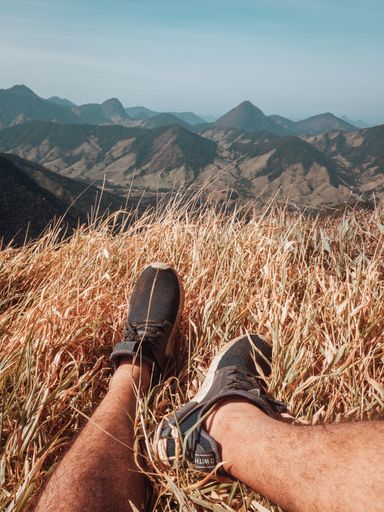 A vertical shot of male feet and the mountains view in Rio de Janeiro