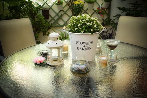 Mesa de descanso en patio interior de casa con plantas y velas.