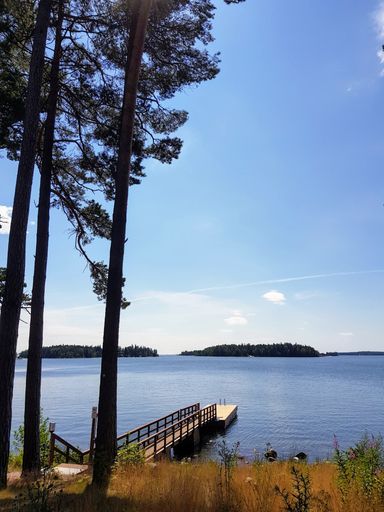 A vertical shot of a pier in a lake under the cloudy skies during the day