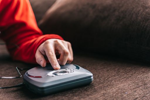 Unrecognizable man with headphones listening to music at home. Relaxed man listening to music on the sofa at home.