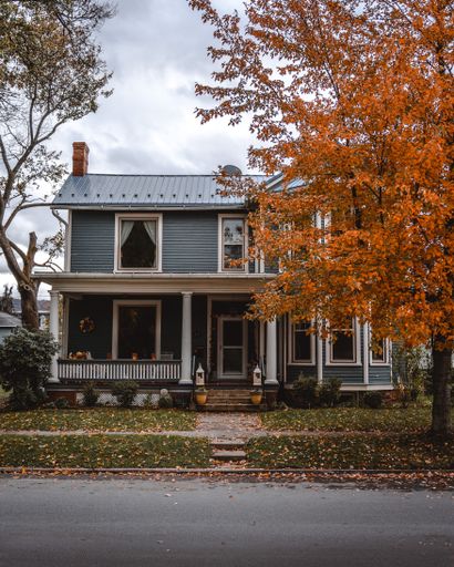 A beautiful private house surrounded by bright orange trees in autumn