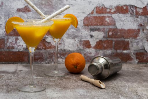 freshly squeezed natural orange cocktail, in a glass with a shaker at the bottom