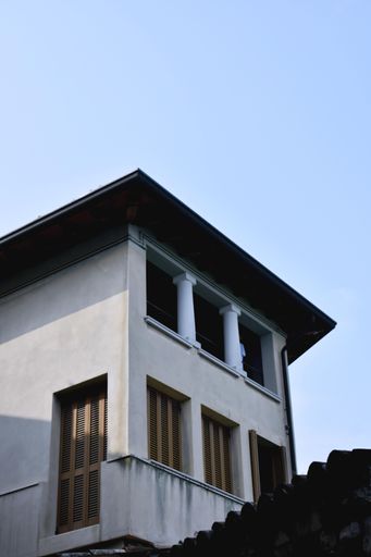 A vertical low angle shot of a white building under a clear blue sky