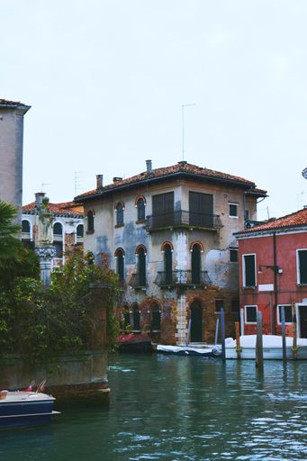 A vertical beautiful shot of boats and buildings in Venice, Italy